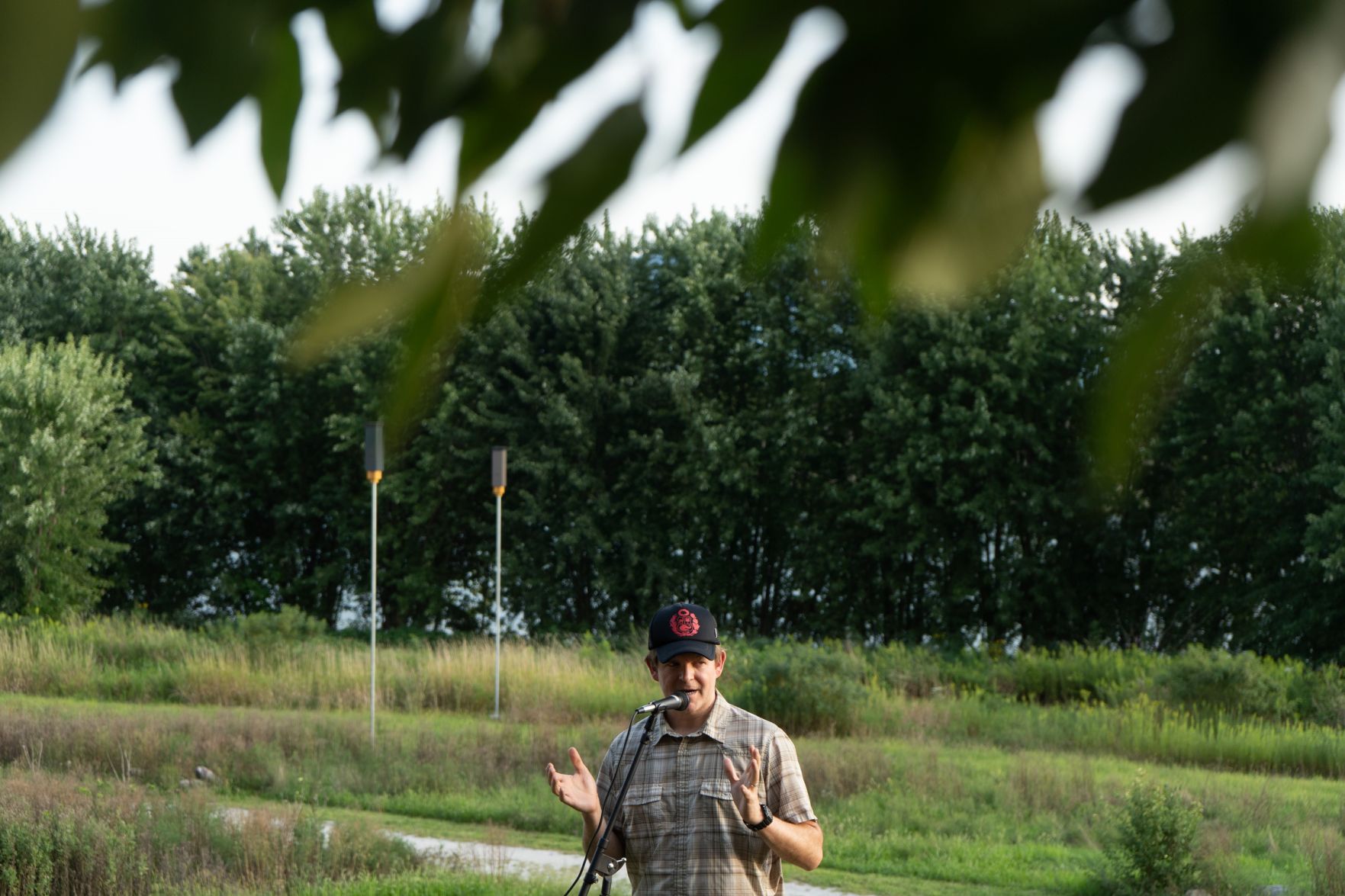Stuart Hyatt speaking with rocket box style bat houses south of the IUPUI campus in the background